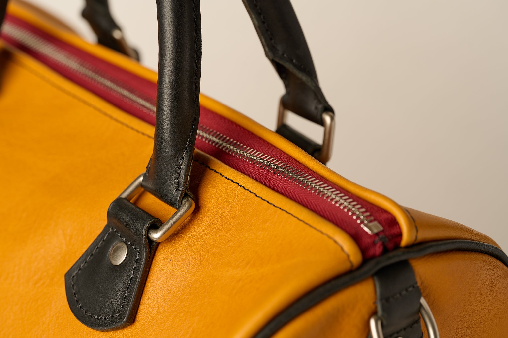 Red zipper details on an Anya Roux leather bag